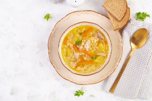 Свежий куриный суп с овощами и звездными макаронами в миске с морковью и петрушкой