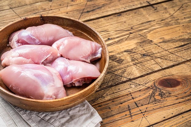 新鮮な鶏もも肉木の板に生の骨なしと皮なしの切り身木製の背景上面図コピースペース