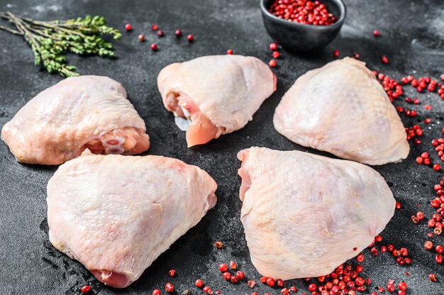 Fresh chicken thigh near spices and herbs