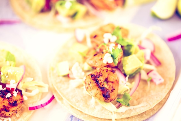 Fresh chipotle shrimp tacos with cotija cheese on a white corn tortillas.