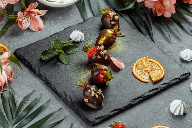 Fresh chocolate covered strawberries on a gray decorative background. Concept for advertising the summer seasonal menu.