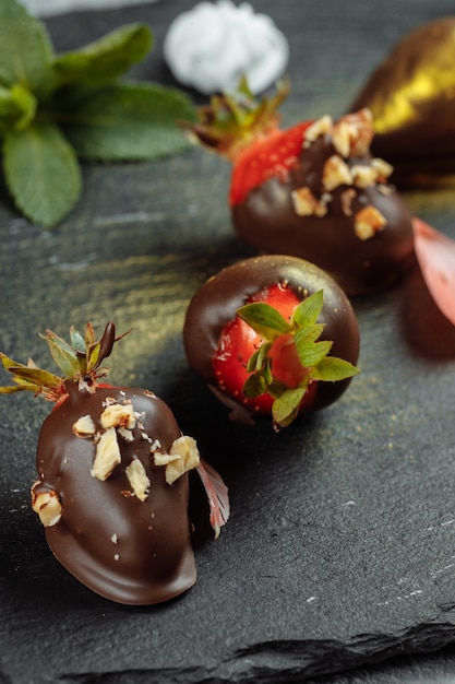 Fresh chocolate covered strawberries on a gray decorative background. Concept for advertising the summer seasonal menu.