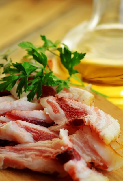 Fresh chopped bacon into thin slices on a wooden board