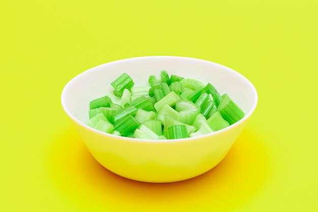 Fresh chopped celery peaces with water drops in white bowl