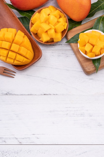 Photo fresh chopped mango on a tray and bright rustic wood table.