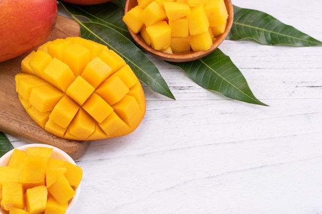 Fresh chopped mango on a tray and bright rustic wooden background Tropical summer fruit design concept close up macro copy space