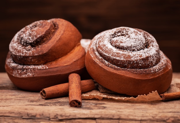 Fresh cinnamon buns on wooden background