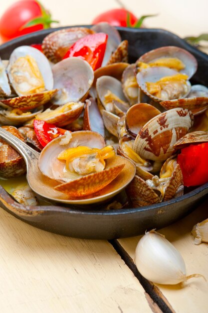 Photo fresh clams on an iron skillet