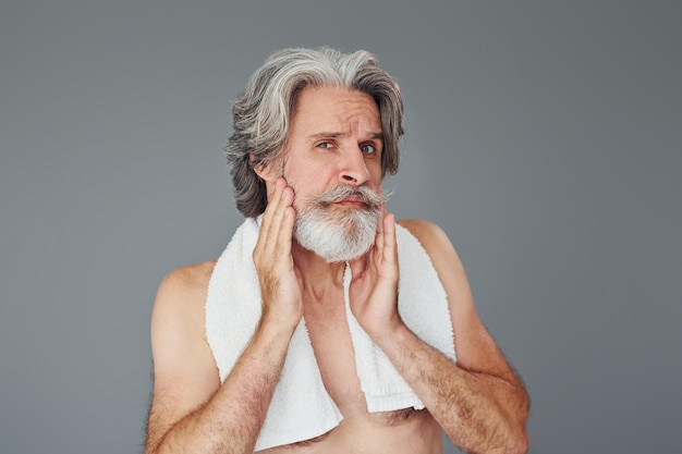 Fresh and clean face Stylish modern senior man with gray hair and beard is indoors