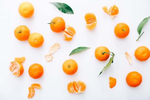 Fresh clementines with leaves on white background, top view