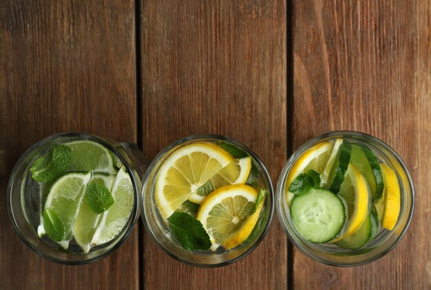 Fresh cocktails with soda lime lemon and cucumber on a wooden background