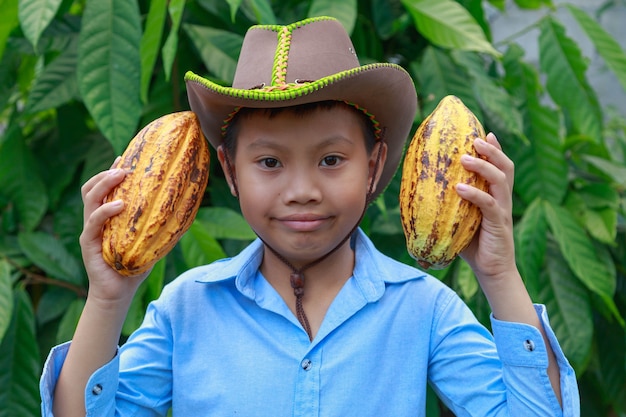 Baccelli di cacao freschi nelle mani di un ragazzo