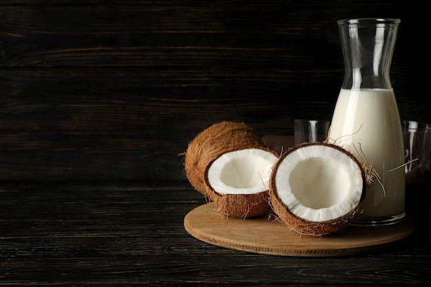 Свежее кокосовое и кокосовое молоко на деревянных фоне