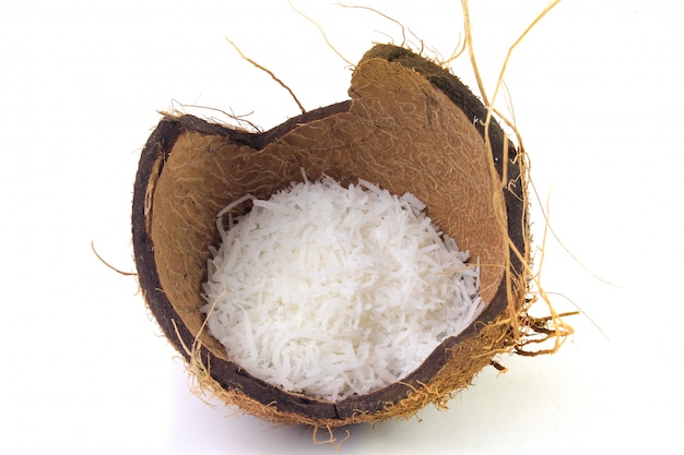 Fresh coconut flakes placed in bark and shell isolated on white background