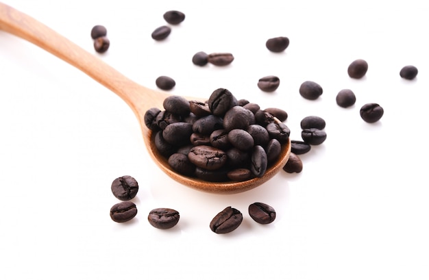 Fresh coffee beans with wooden spoon isolated on white background