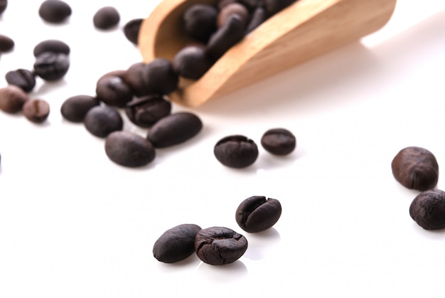 木のスプーンで白い背景で隔離の新鮮なコーヒー豆