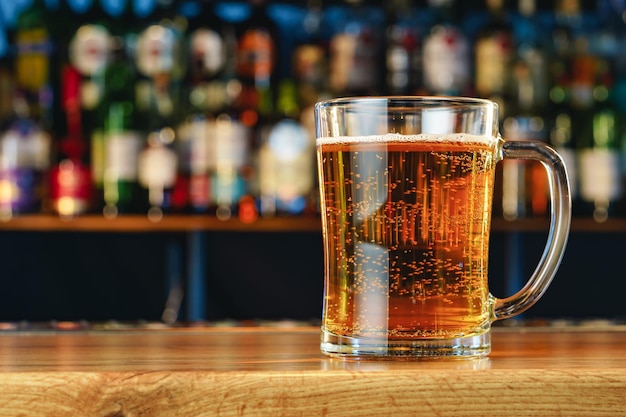 Fresh cold beer in glass on bar background