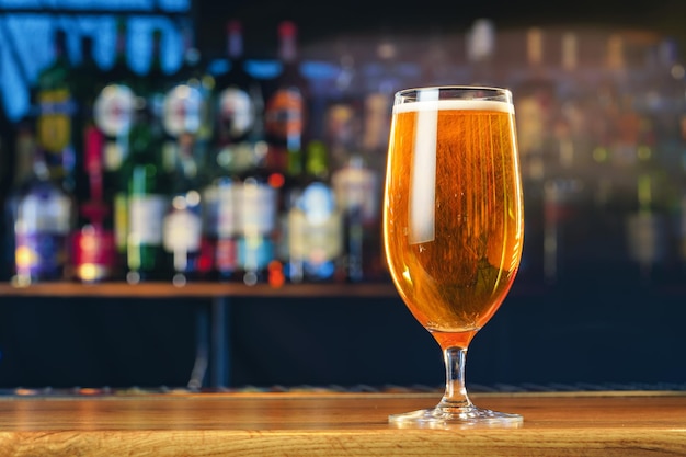 Fresh cold beer in glass on bar background