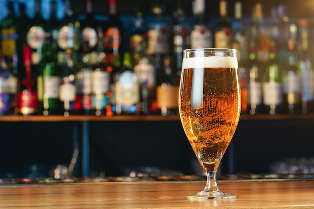 Fresh cold beer in glass on bar background