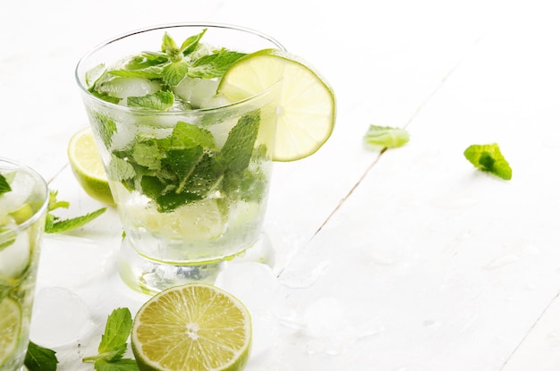 Fresh cold lime mojito on white table