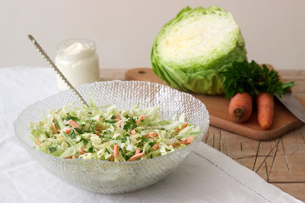 Fresh coleslaw salad in bowl and ingredients for salad. Rustic style.