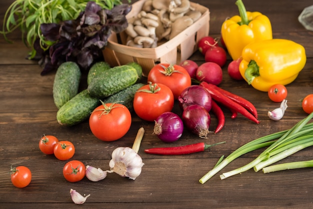 Fresh colorful vegetables from a kitchen garden on a dark wooden background