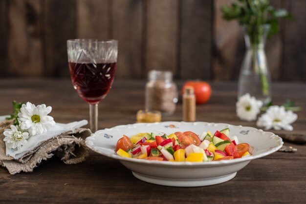 Fresh colorful vegetables on a white plate on a dark wooden background