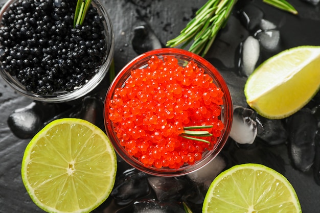 Fresh composition with caviar and citrus on black table, close up