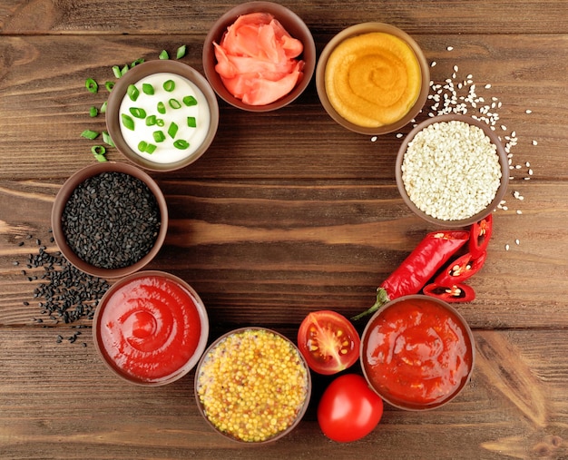 Fresh condiments and sauces on wooden background