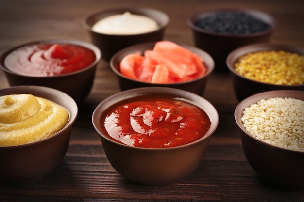 Fresh condiments and sauces on wooden table, closeup