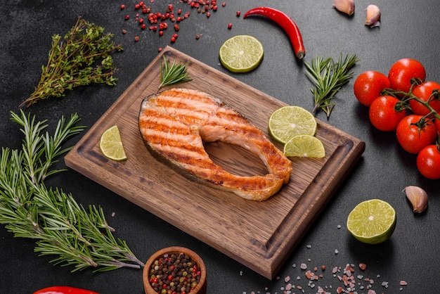 Fresh cooked delicious salmon steak with spices and herbs baked on a grill. Healthy seafood food