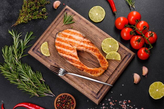 Fresh cooked delicious salmon steak with spices and herbs baked on a grill.