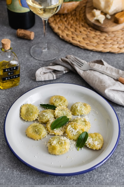 Foto ravioli italiani cucinati freschi con la ricotta e gli spinaci sulla tavola grigia