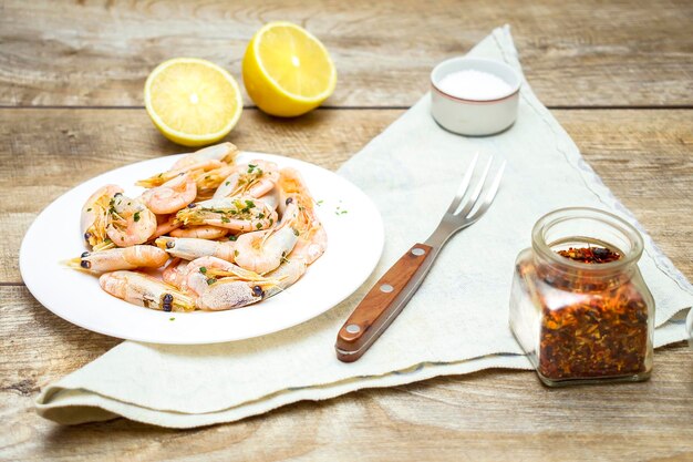 Fresh cooked shrimp prawns on white plate with lemon salt and spices Delicious healthy seafood protein meal