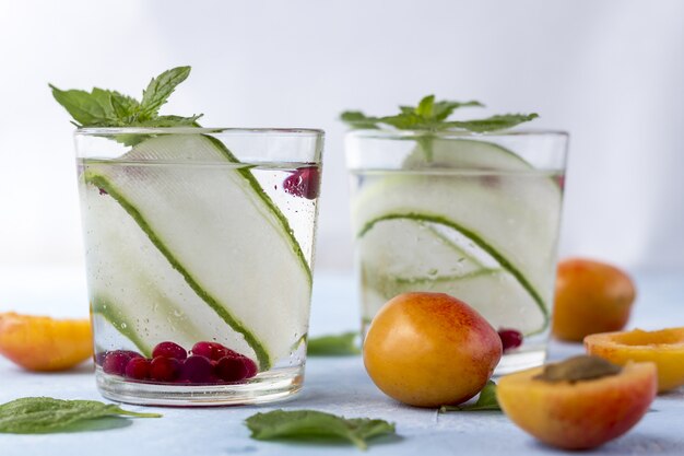 Fresh cool detox drink with cucumber, berries and peaches or aprikotes.