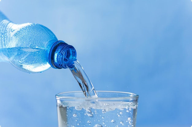 Foto l'acqua fresca e fresca scorre dal collo della bottiglia