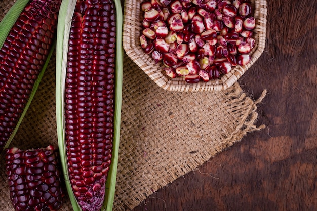 fresh corn on cobs on rustic wooden table, closeup