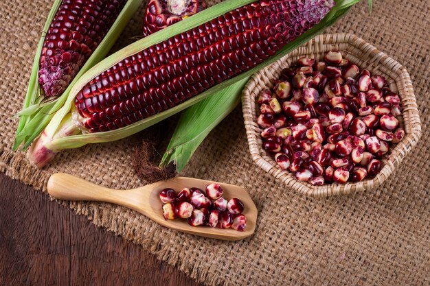 fresh corn on cobs on rustic wooden table, closeup