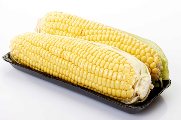 Fresh corn cobs on tray, close-up