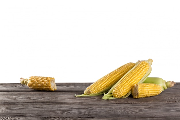 Fresh corn cobs on wooden table