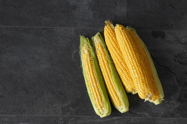 Fresh corn on the dark wooden background