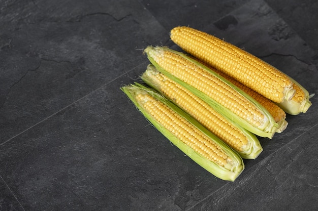 Fresh corn on the dark wooden background