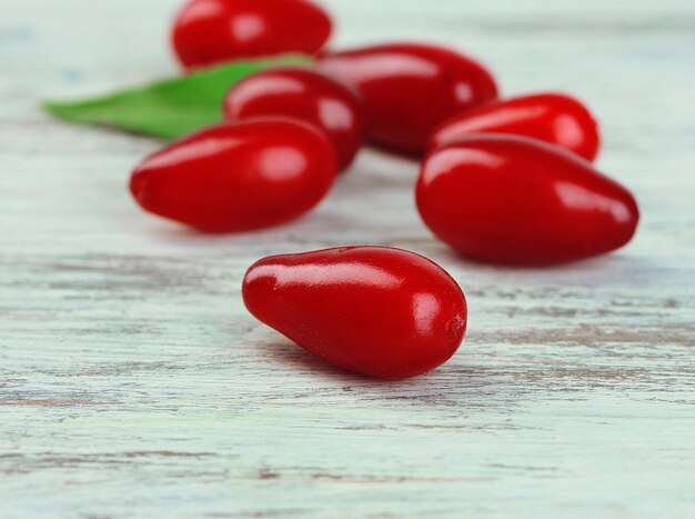 Fresh cornel berries on wooden background