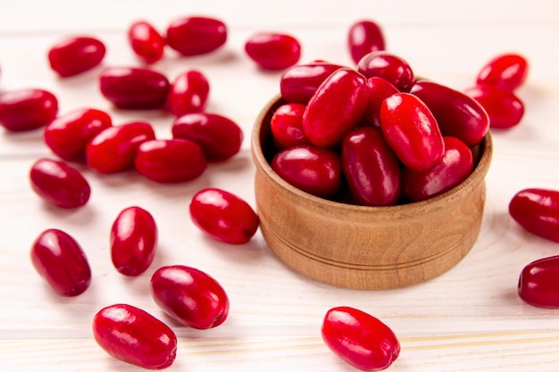 Fresh cornela berries on a white wooden background Dogwood berries