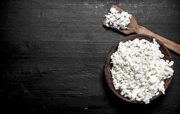 Fresh cottage cheese in a bowl. On the black chalkboard.