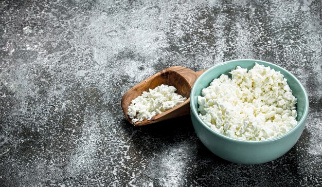 Fresh cottage cheese in a bowl on rustic table.