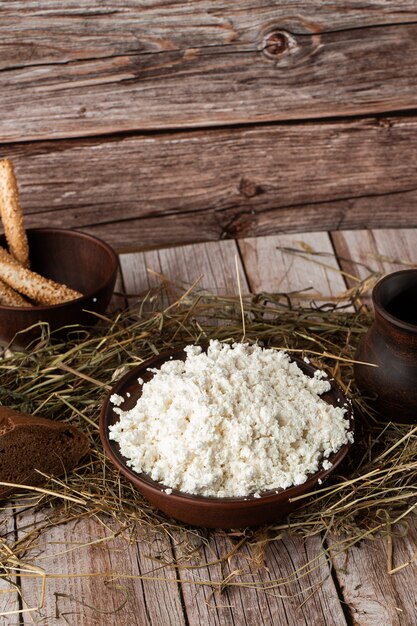 Fresh cottage cheese in a wooden bowl with a spoon