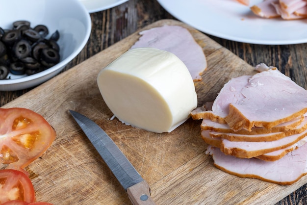 Fresh cow's milk cheese is cut on a board