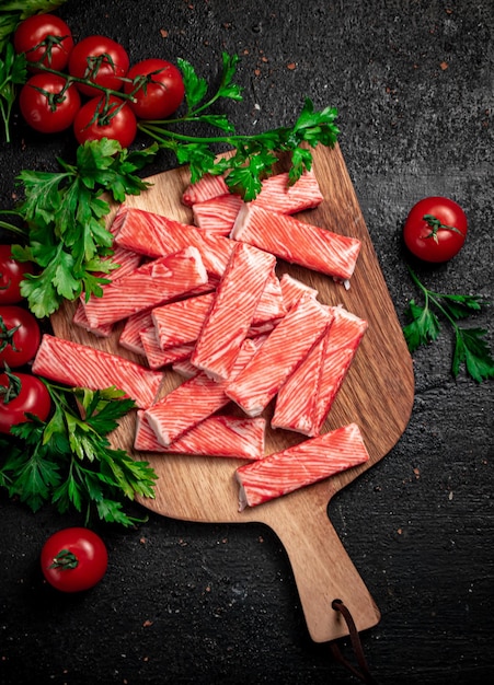 Fresh crab meat on a cutting board with parsley and tomatoes