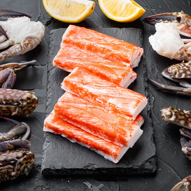 fresh crab meat surimi with blue swimming crab set, on stone board, on black table